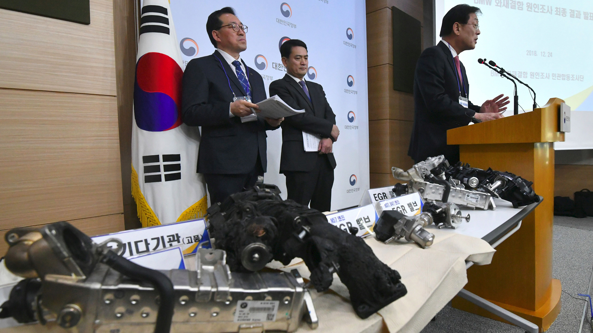 Parts of a burnt BMW car are displayed on a table during a press conference announcing the result of a five-month joint probe into BMW car engine fires, held at the South Korean government complex in Seoul on Dec. 24, 2018. (Credit: Jung Yeon-Je/AFP/Getty Images)