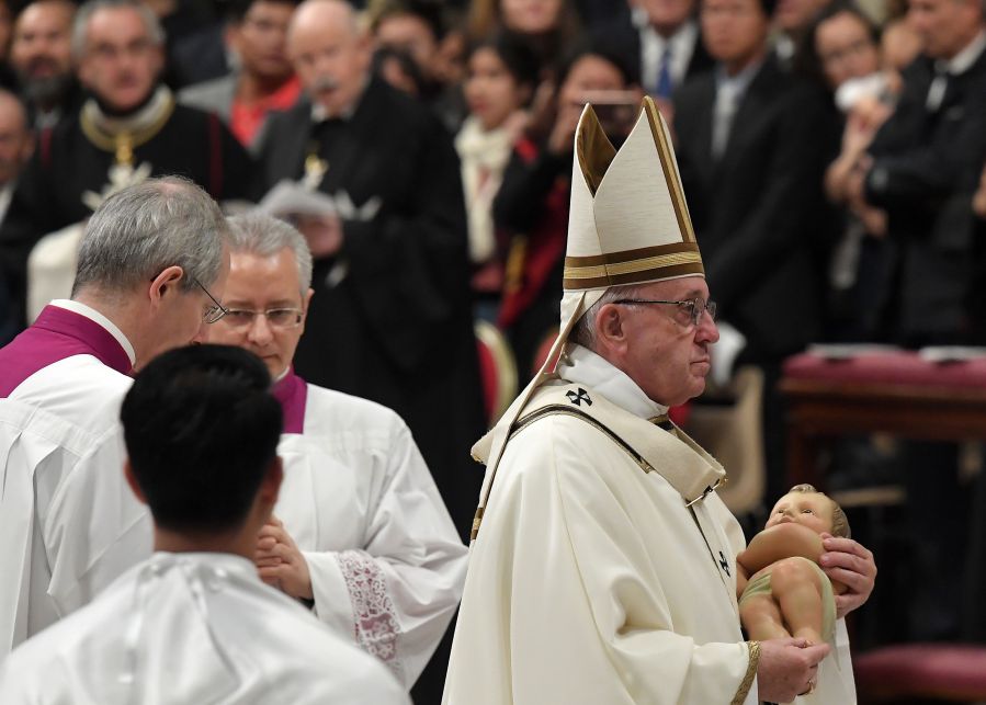 Pope Francis cradles a statue of baby Jesus at end of mass on Christmas eve marking the birth of Jesus Christ on Dec. 24, 2018, at St Peter's Basilica in Vatican. (Credit: TIZIANA FABI/AFP/Getty Images)