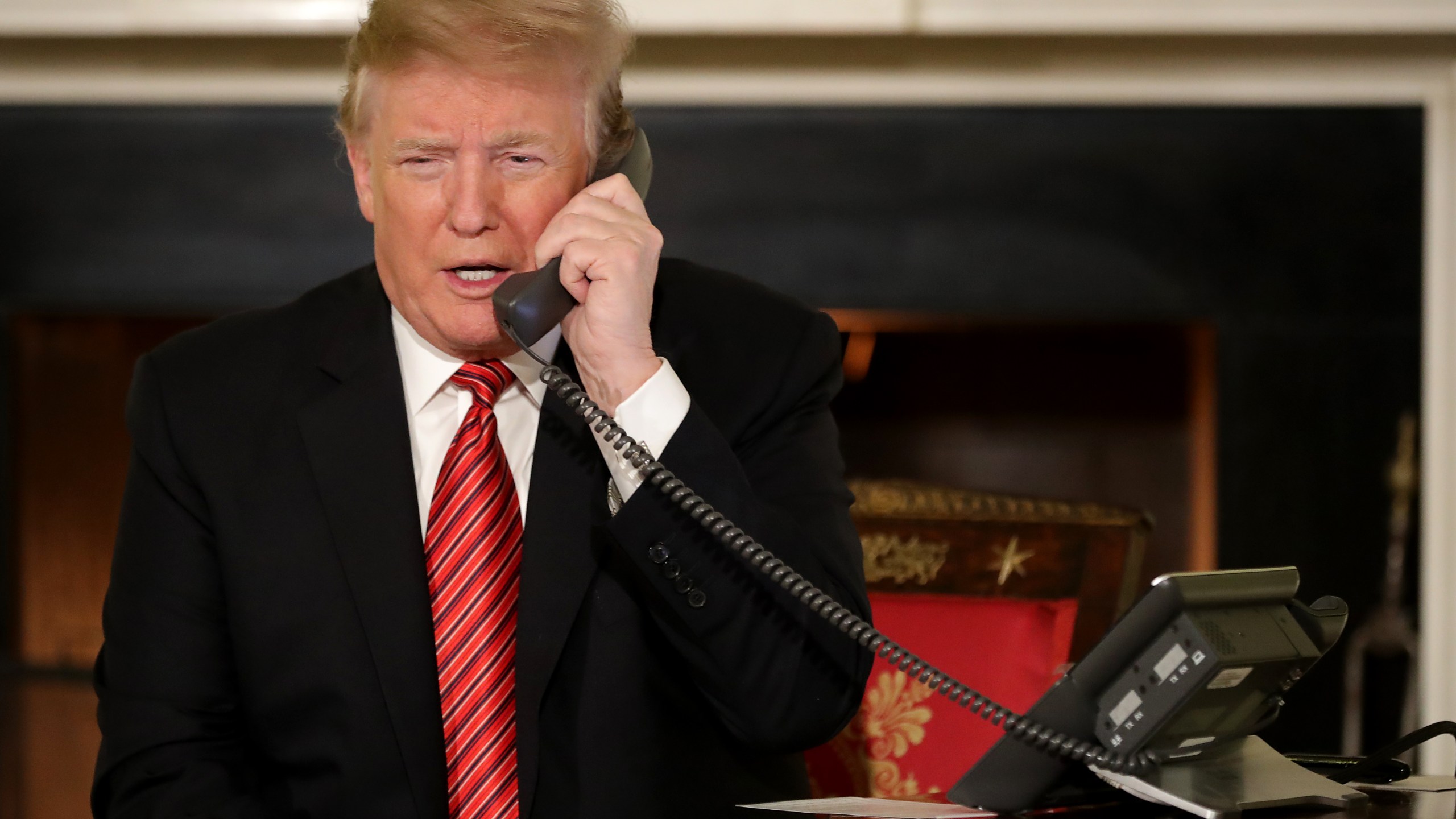 U.S. President Donald Trump takes phone calls from children as he participates in tracking Santa Claus' movements with the North American Aerospace Defense Command (NORAD) Santa Tracker on Christmas Eve in the East Room of the White House Dec. 24, 2018, in Washington, D.C. (Credit: Chip Somodevilla/Getty Images)