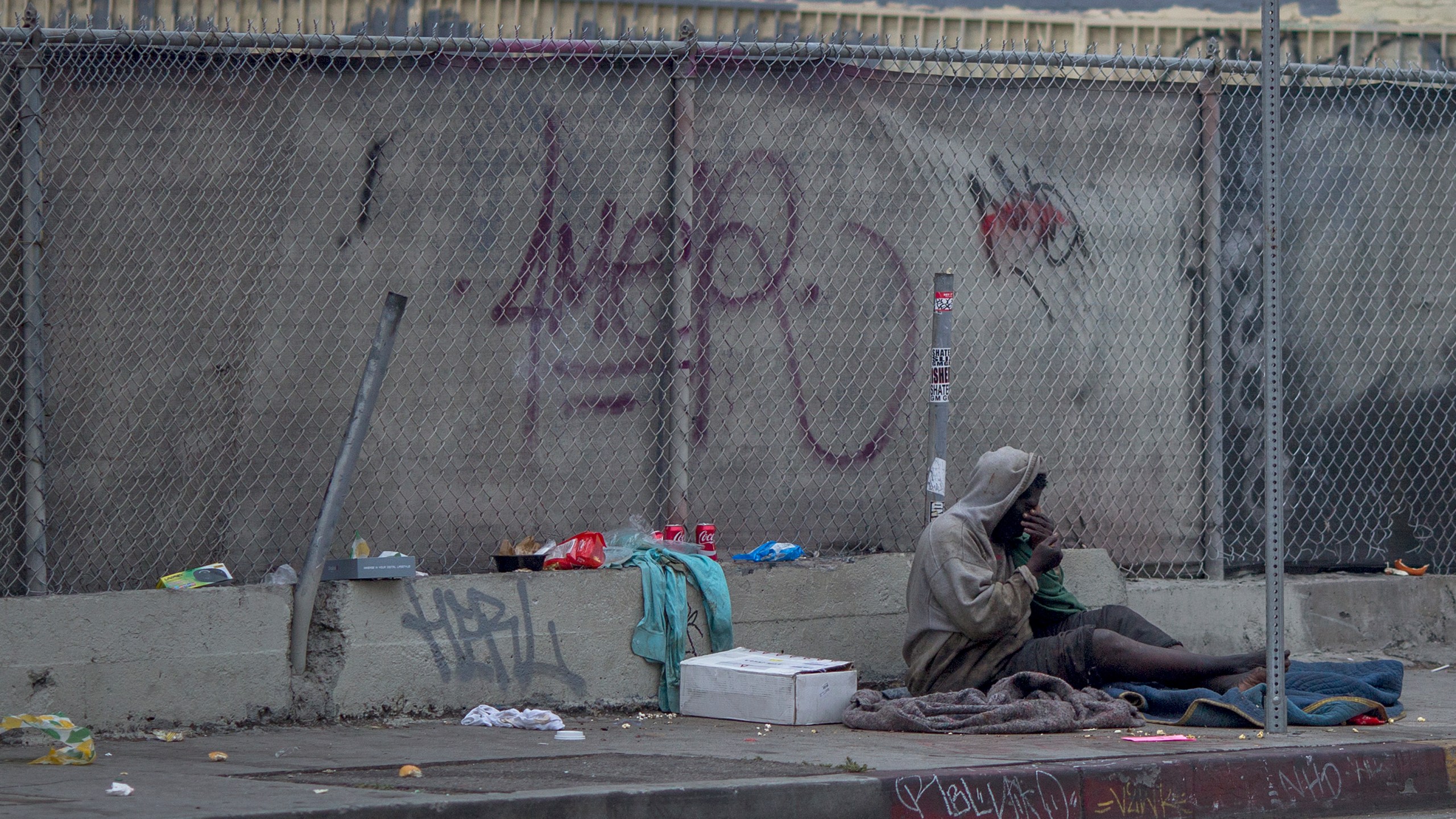 A homeless man sits on a downtown sidewalk where he had slept on May 1, 2017 in Los Angeles, California. (Credit: David McNew/Getty Images)