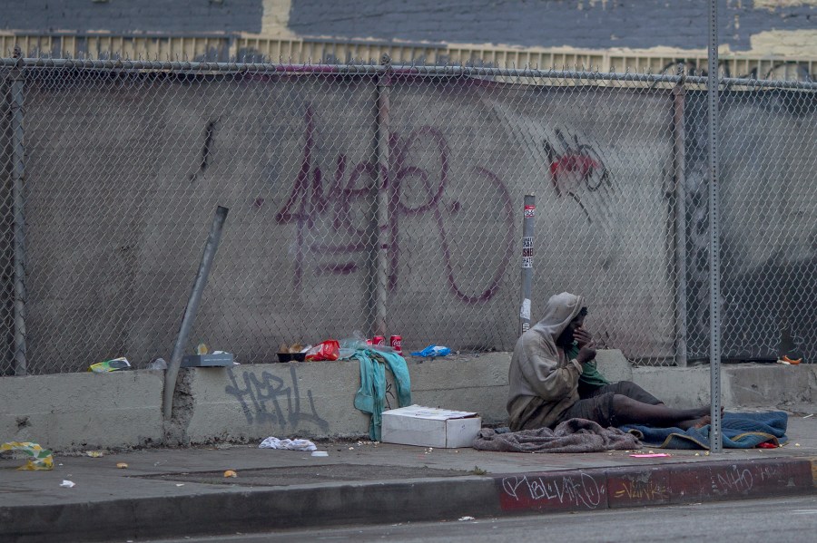 A homeless man sits on a downtown sidewalk where he had slept on May 1, 2017 in Los Angeles, California. (Credit: David McNew/Getty Images)