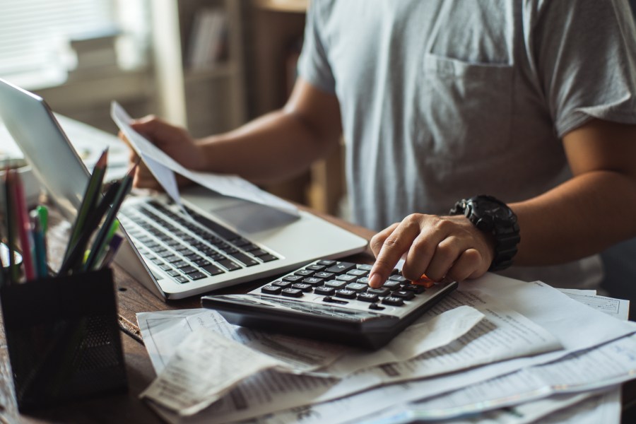 A man calculates the cost of a bill in this file photo. (Credit: Getty Images)