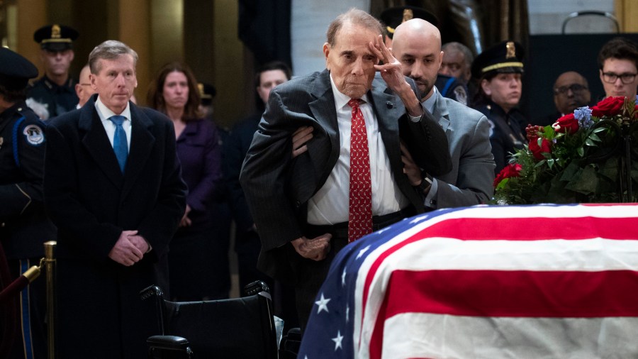 Former Senator Bob Dole salutes before the flag-draped casket of George H. W. Bush at the Capitol rotunda December 4, 2018. (Credit: ALEX EDELMAN/AFP/Getty Images)