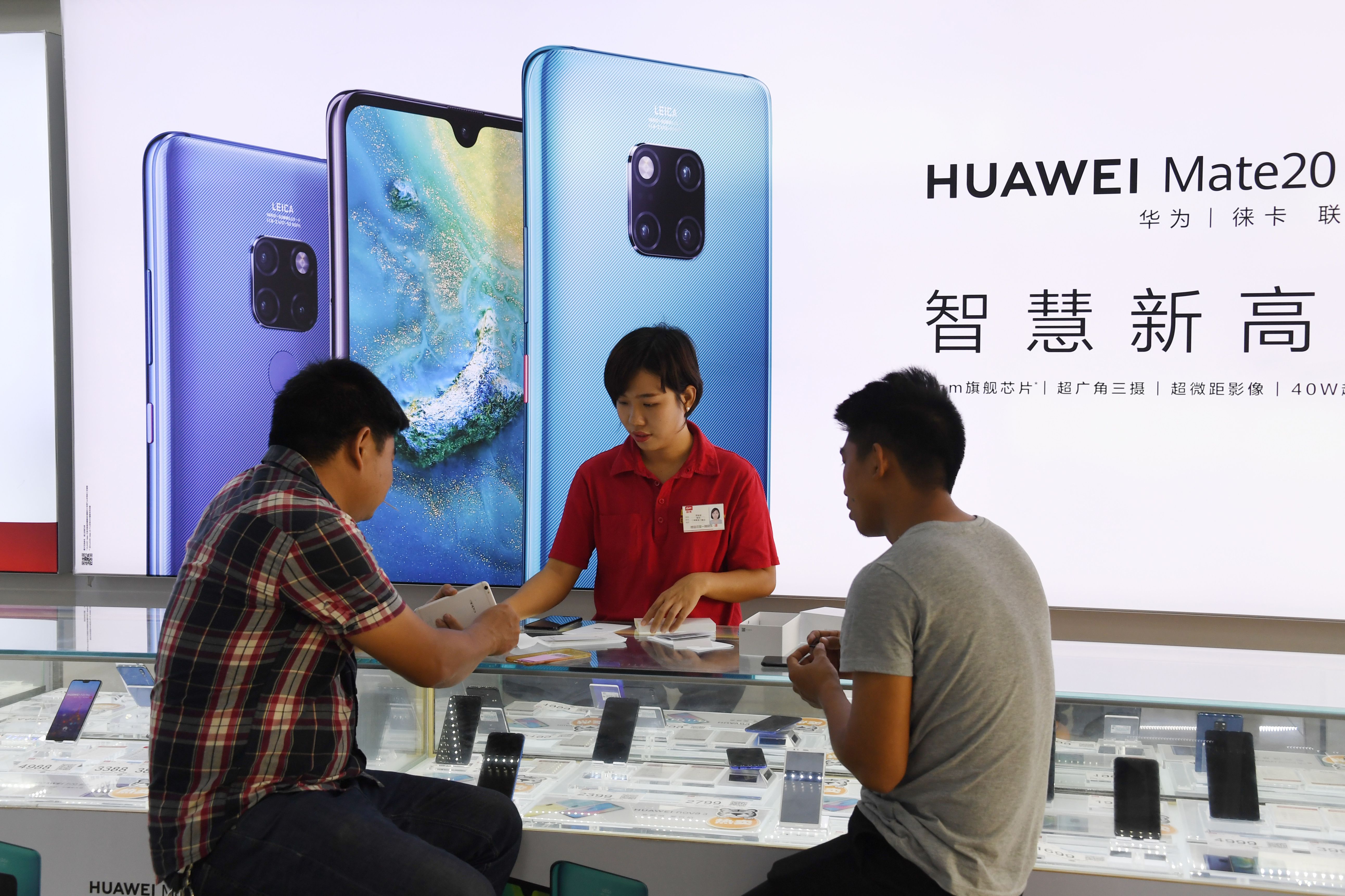 Customers are served at a Huawei stand in a store in Sanya on China's tropical Hainan Island on December 8, 2018.(Credit: Greg Baker/AFPGetty Images)