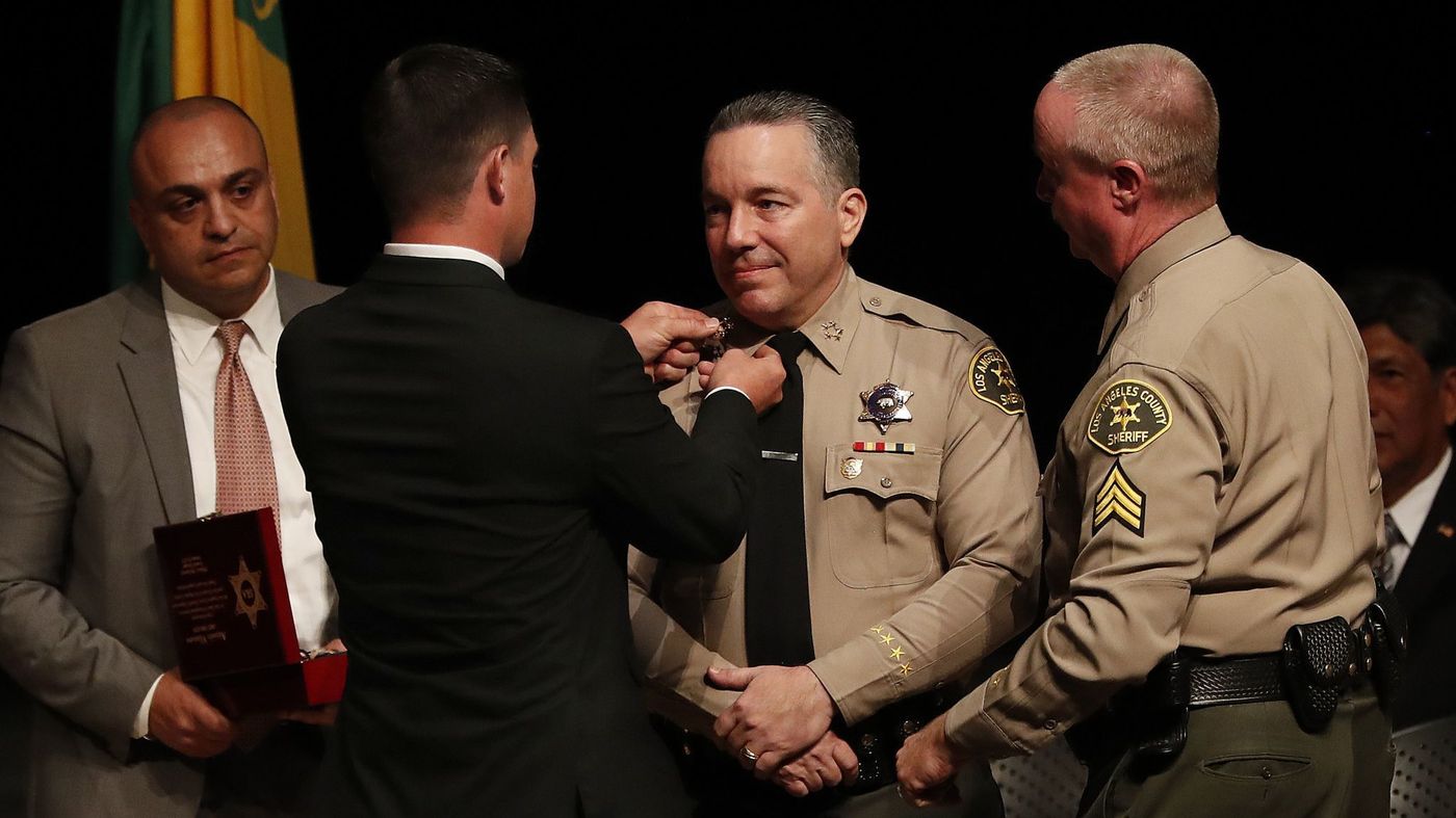 Jared Villanueva places a pin on the collar of his father, Alex Villanueva, at his swearing-in as Los Angeles County sheriff on Dec. 3, 2018. (Credit: Mel Melcon / Los Angeles Times)