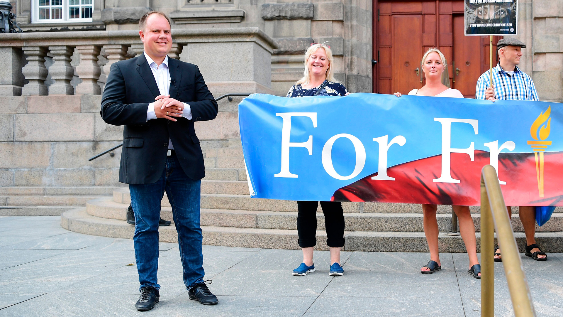 Danish People's Partys Martin Henriksen, left, stands in front of the Danish Parliament during a demonstration organized by For Frihed - "For Freedom" -- in Copenhagen, Denmark, on August 1, 2018. (Credit: BAX LINDHARDT/AFP/Getty Images)