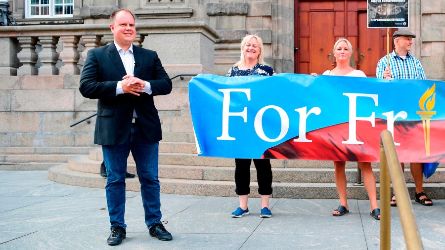 Danish People's Partys Martin Henriksen, left, stands in front of the Danish Parliament during a demonstration organized by For Frihed - "For Freedom" -- in Copenhagen, Denmark, on August 1, 2018. (Credit: BAX LINDHARDT/AFP/Getty Images)