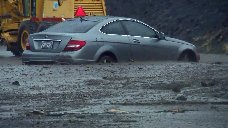 A vehicle is trapped in debris on Pacific Coast Highway near Leo Carrillo State Beach following heavy showers on Dec. 6, 2018. (Credit: KTLA)