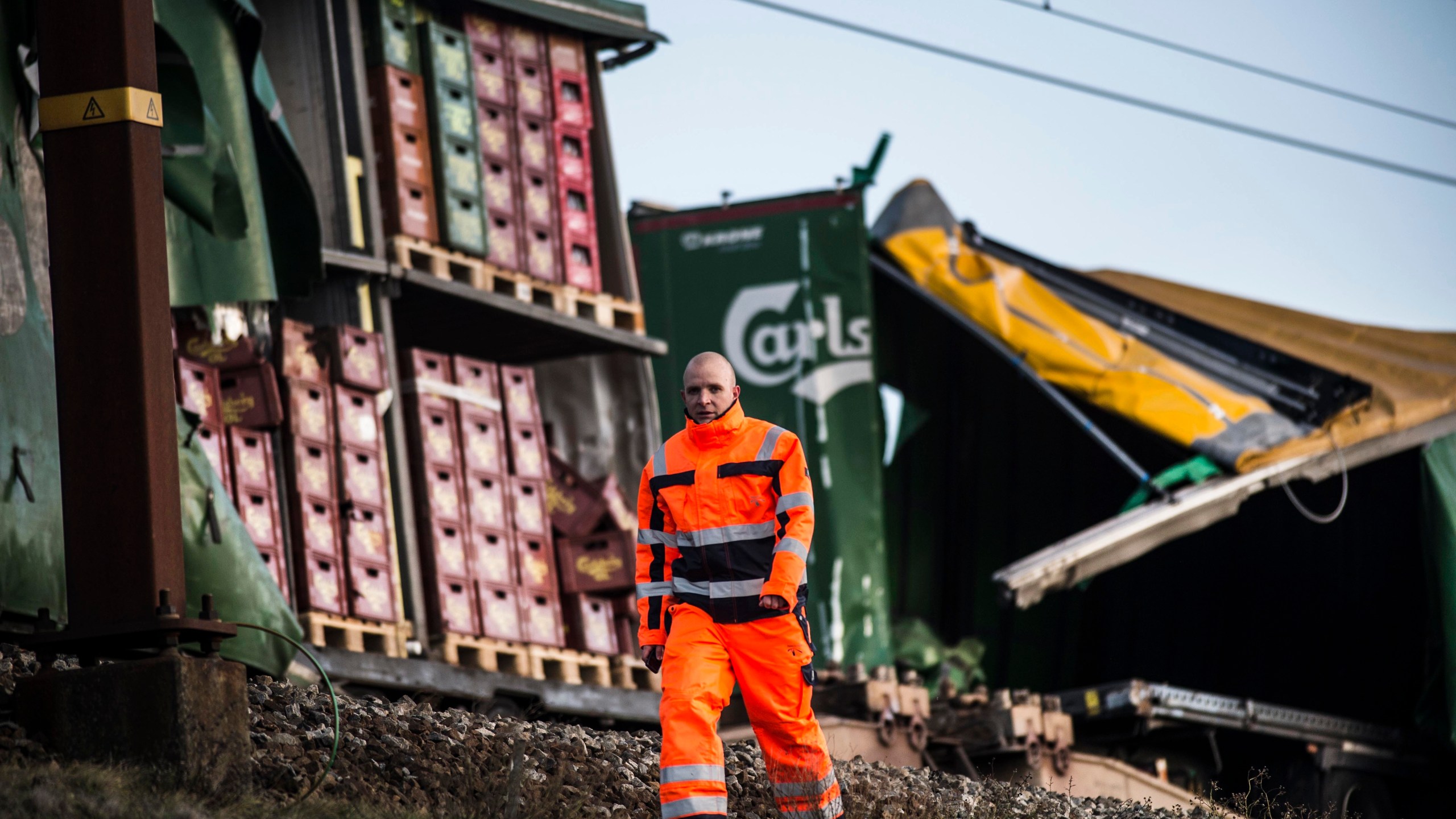 A staff member walks past damaged containers on a cargo train on the Great Belt Bridge after a railway accident on January 2, 2019 in Nyborg, Denmark. (Credit: TIM KILDEBORG JENSEN/AFP/Getty Images)