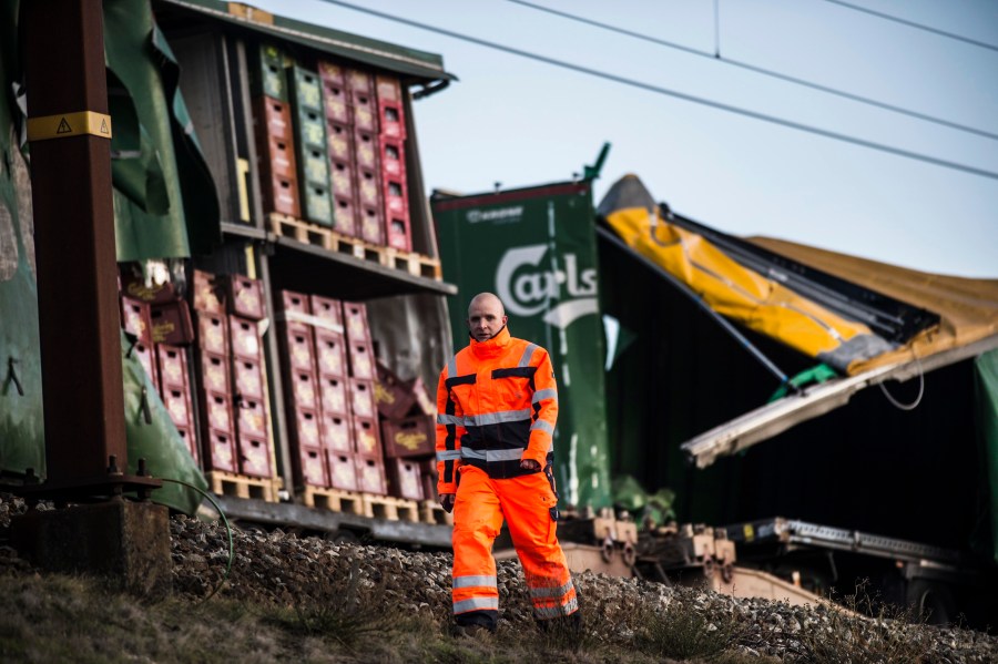 A staff member walks past damaged containers on a cargo train on the Great Belt Bridge after a railway accident on January 2, 2019 in Nyborg, Denmark. (Credit: TIM KILDEBORG JENSEN/AFP/Getty Images)