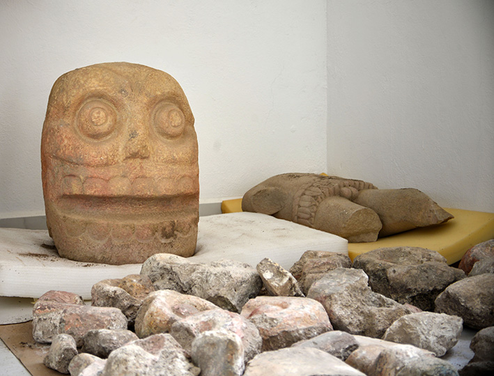 A skull-like stone carving and stone trunk depicting the Flayed Lord, a pre-Hispanic fertility god, are stored after being excavated from an archaeological site in Tehuacan in this 2018 photo provided by Mexico's National Institute of Anthropology and History.