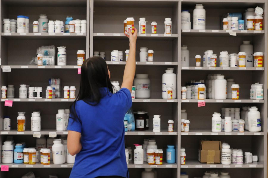 A pharmacy technician grabs a bottle of medication off a shelf on Sept. 10, 2018 in Midvale, Utah. (Credit: George Frey/Getty Images)