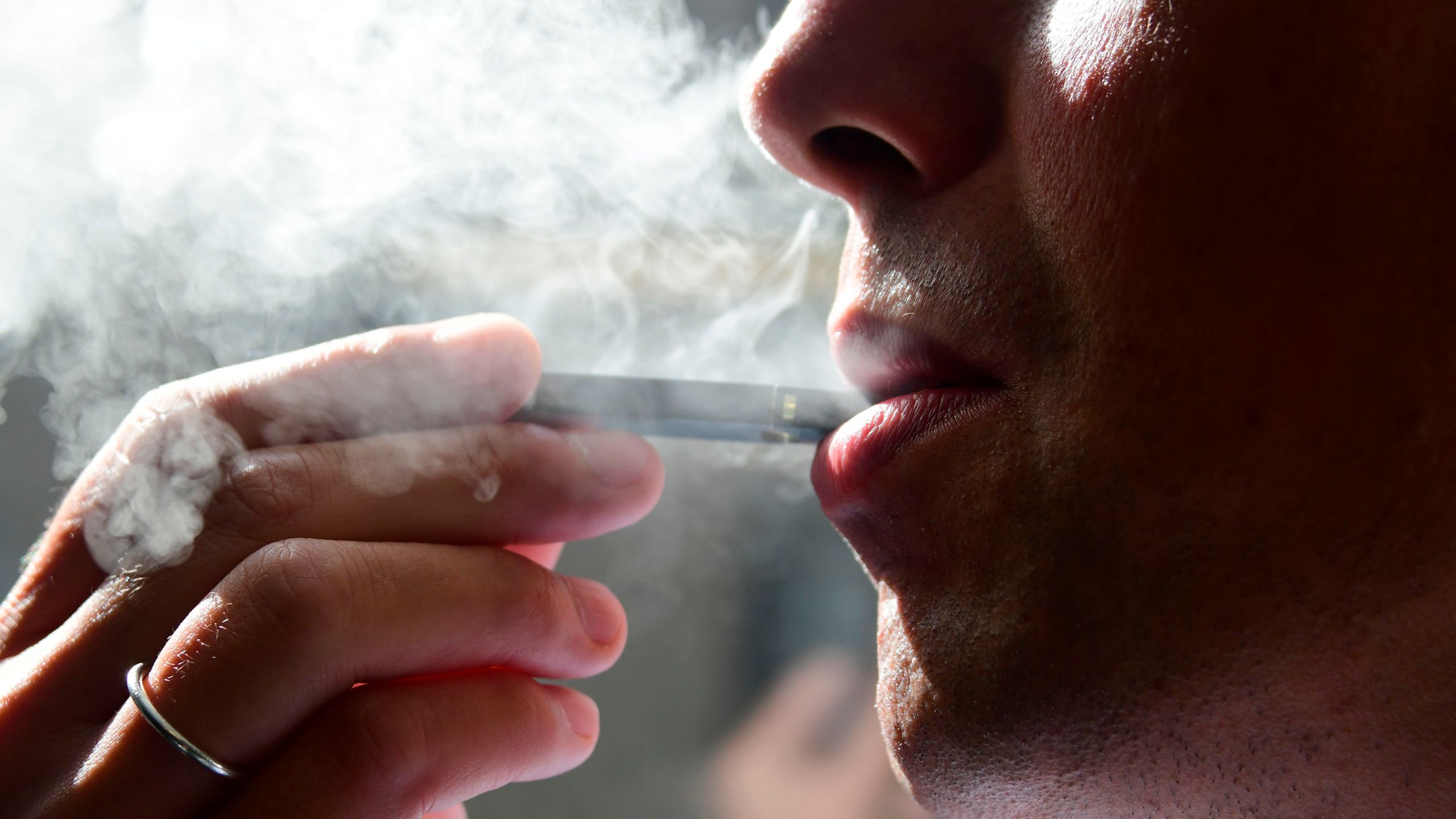 An image shows a man exhaling smoke from an e-cigarette in Washington, D.C. on Oct. 2, 2018.(Credit: Eva Hambach/AFP/Getty Images)