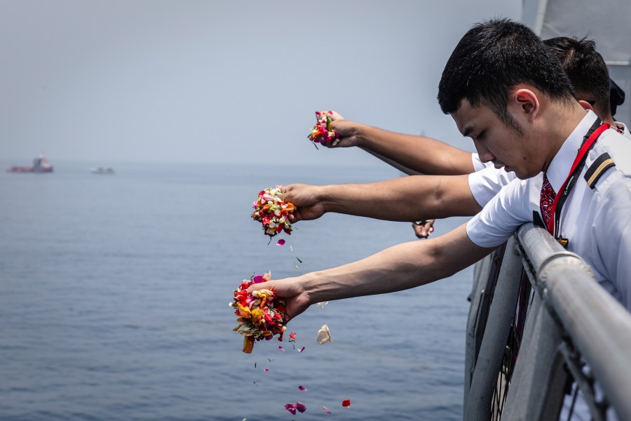 Colleagues of victims of Lion Air flight JT 610 throw flowers on deck of the Indonesian Navy ship KRI Banjarmasin during a visit to the crash site on November 6, 2018 in Karawang, Indonesia. (Credit: Ulet Ifansasti/Getty Images)