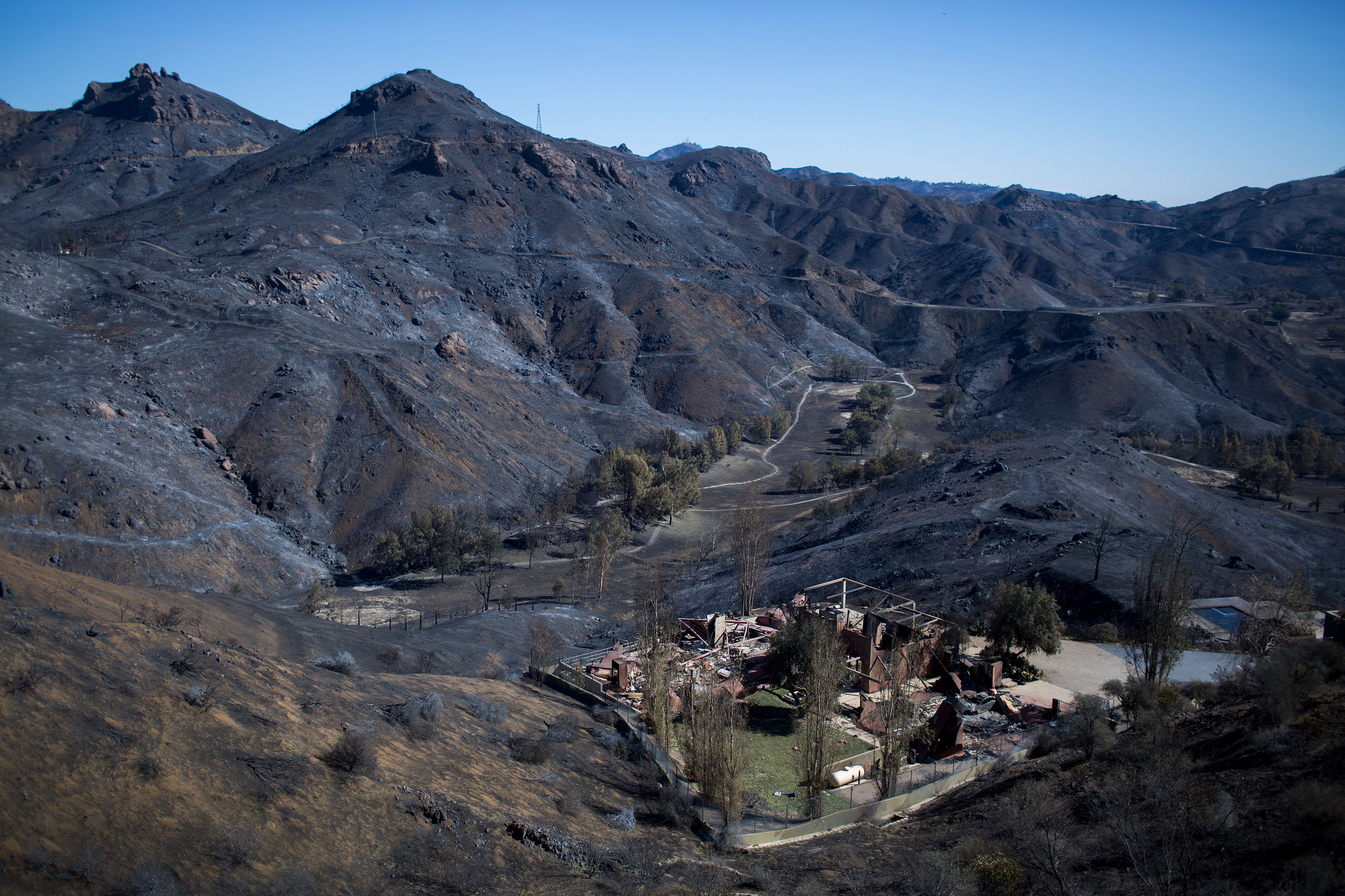 The Santa Monica Mountains are seen left blackened by the Woolsey Fire near Malibu on Nov. 14, 2018. (David McNew / AFP / Getty Images)