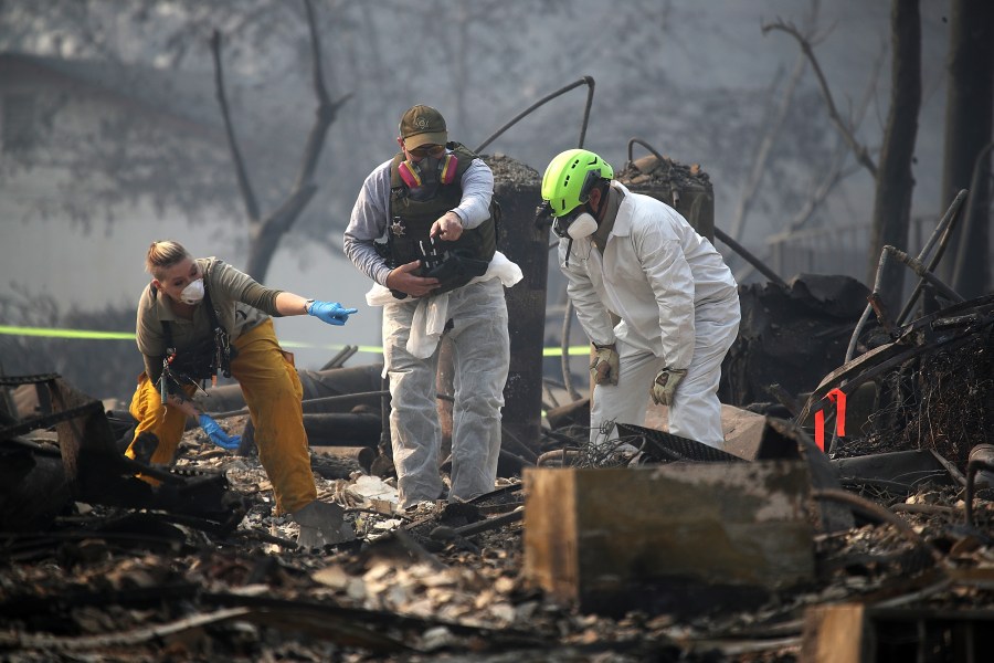 Rescue workers search an area where they discovered suspected human remains in a home in Paradise destroyed by the Camp Fire on Nov. 16, 2018. (Credit: Justin Sullivan / Getty Images)