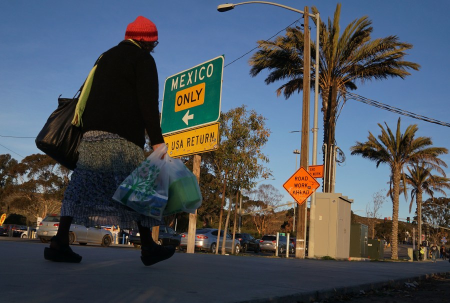 Shoppers walk towards the San Ysidro Port of Entry after making purchases at outlet malls along the U.S.-Mexico border on Dec. 29, 2018 in San Ysidro. (Credit: SANDY HUFFAKER/AFP/Getty Images)