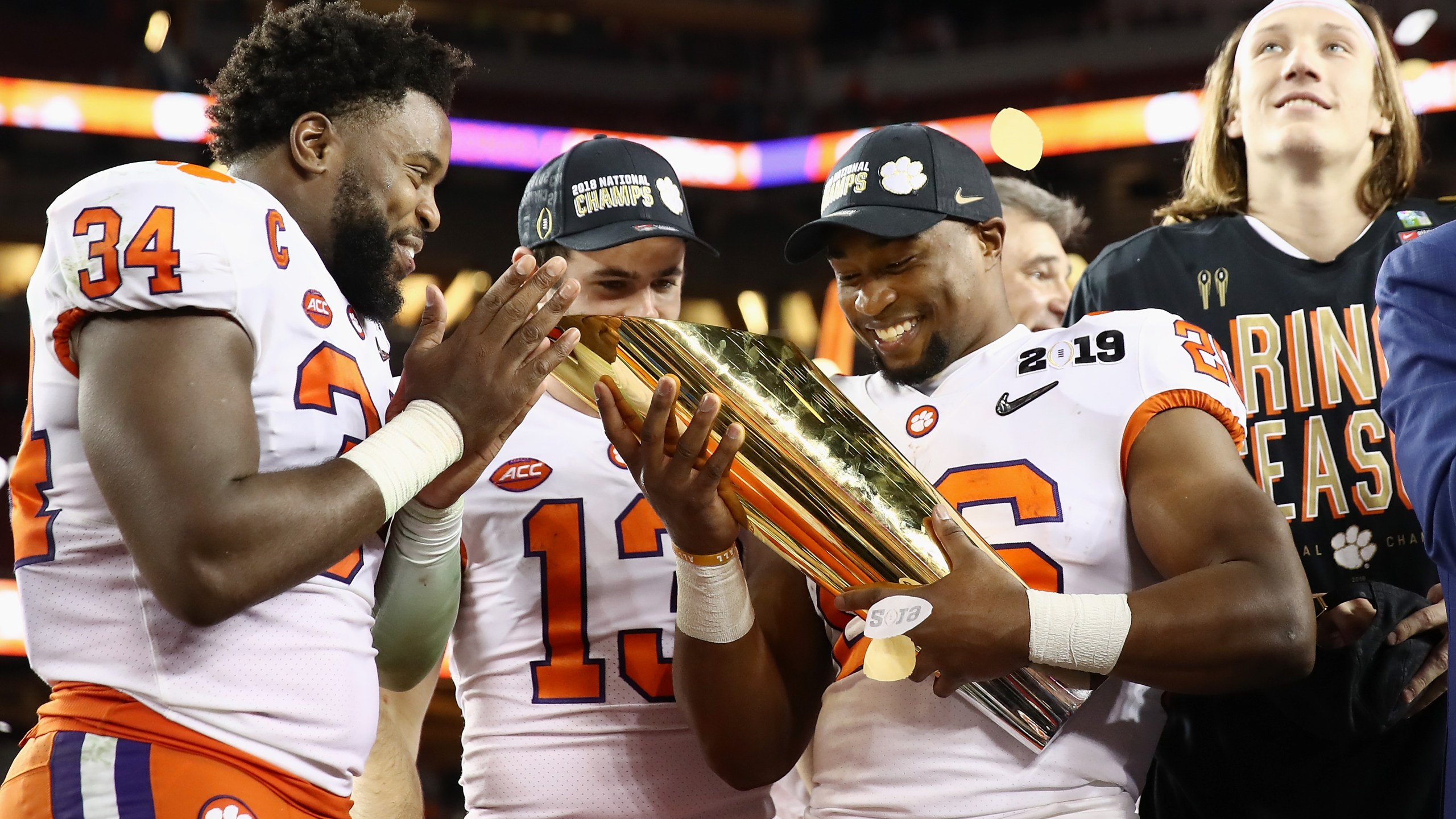 Kendall Joseph #34, Hunter Renfrow #13 and Adam Choice #26 of the Clemson Tigers celebrate with the trophy after their 44-16 win over the Alabama Crimson Tide in the CFP National Championship presented by AT&T at Levi's Stadium on January 7, 2019 in Santa Clara. (Credit: Ezra Shaw/Getty Images)