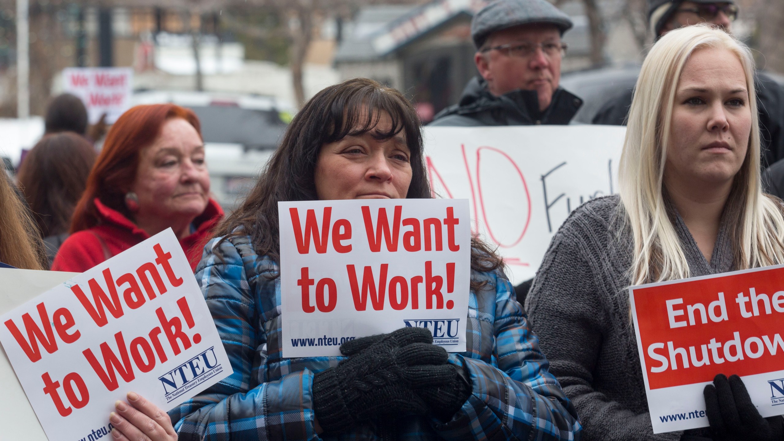 IRS employee Donna Orton (C) holds a sign protesting the government shutdown at the James V. Hansen Federal Building on January 10, 2019 in Ogden, Utah. (Credit: Natalie Behring/Getty Images)