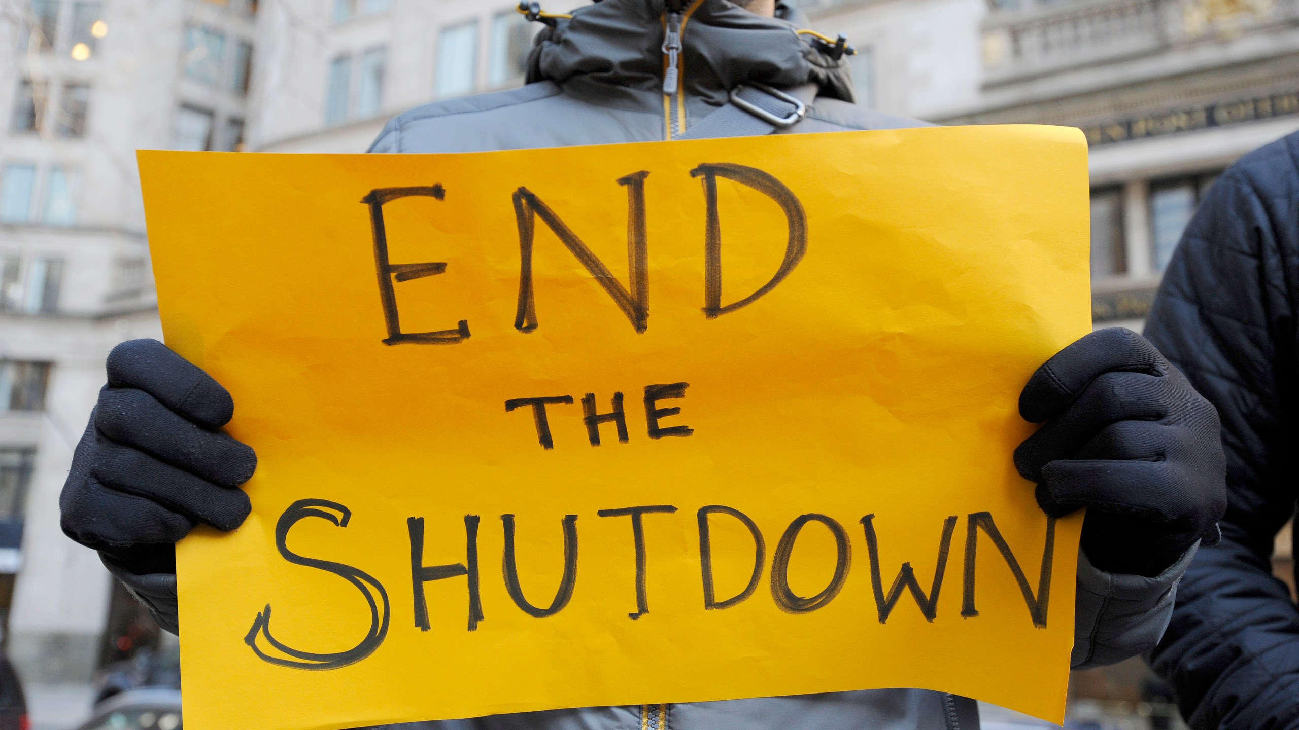 Protesters hold signs during a rally against the government shutdown on Jan. 11, 2019, in Boston. (Credit: Joseph Preziodo/AFP/Getty Images)