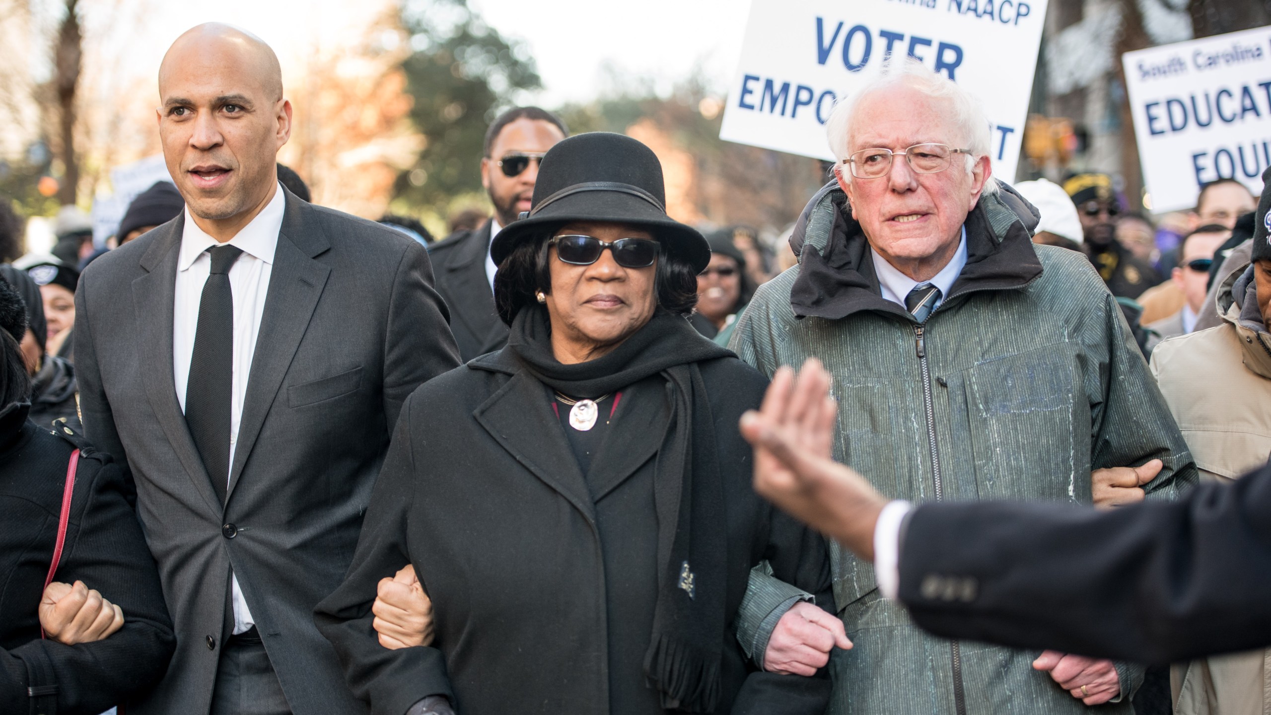 U.S. Sen. Bernie Sanders (I-VT), right, president of the South Carolina NAACP chapter, Brenda Murphy, center, and Sen. Cory Booker (D-NJ) march to the Statehouse in commemoration of Martin Luther King Jr. Day on Jan. 21, 2019, in Columbia, South Carolina. (Credit: Sean Rayford/Getty Images)