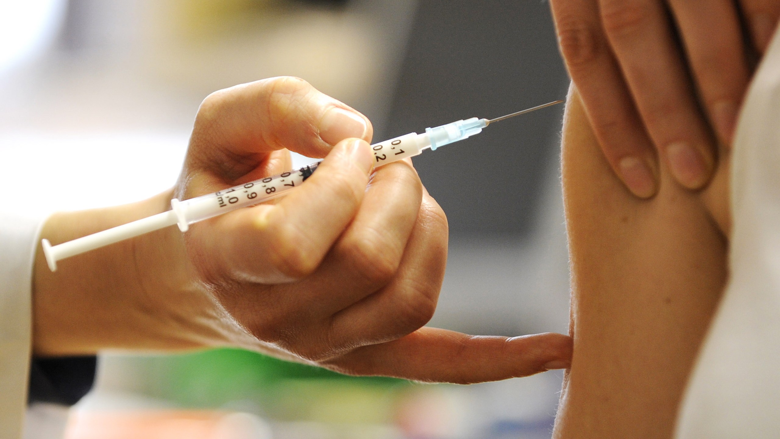 A woman receives a vaccine in this file photo. (Credit: Norbert Millauer / AFP / Getty Images)