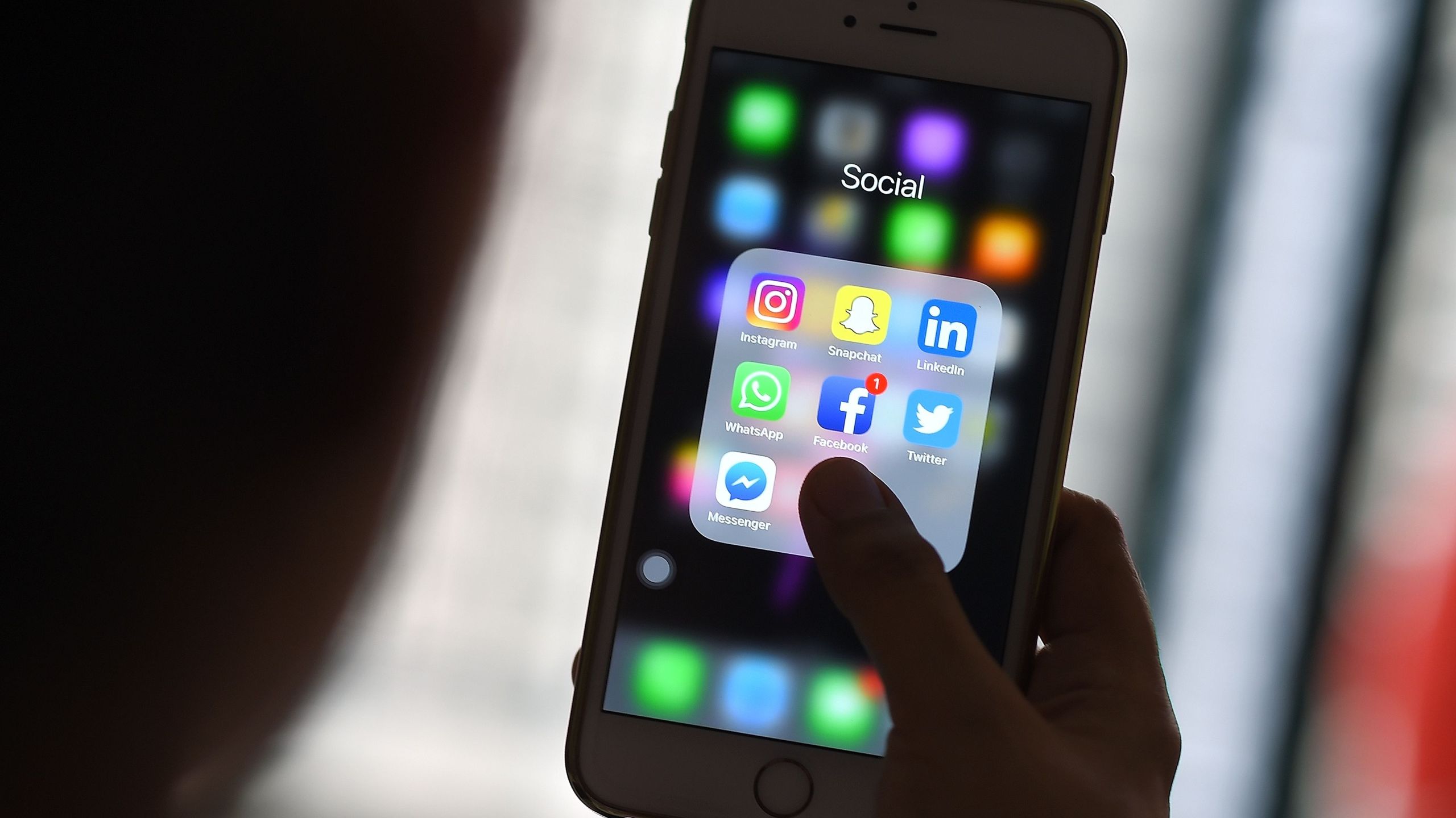 This photo illustration taken on March 22, 2018, shows a woman looking at social networking applications Facebook, Instagram, Snapchat, WhatsApp, Twitter, Messenger and LinkedIn on a smartphone in Kuala Lumpur. (Credit: MANAN VATSYAYANA/AFP/Getty Images)