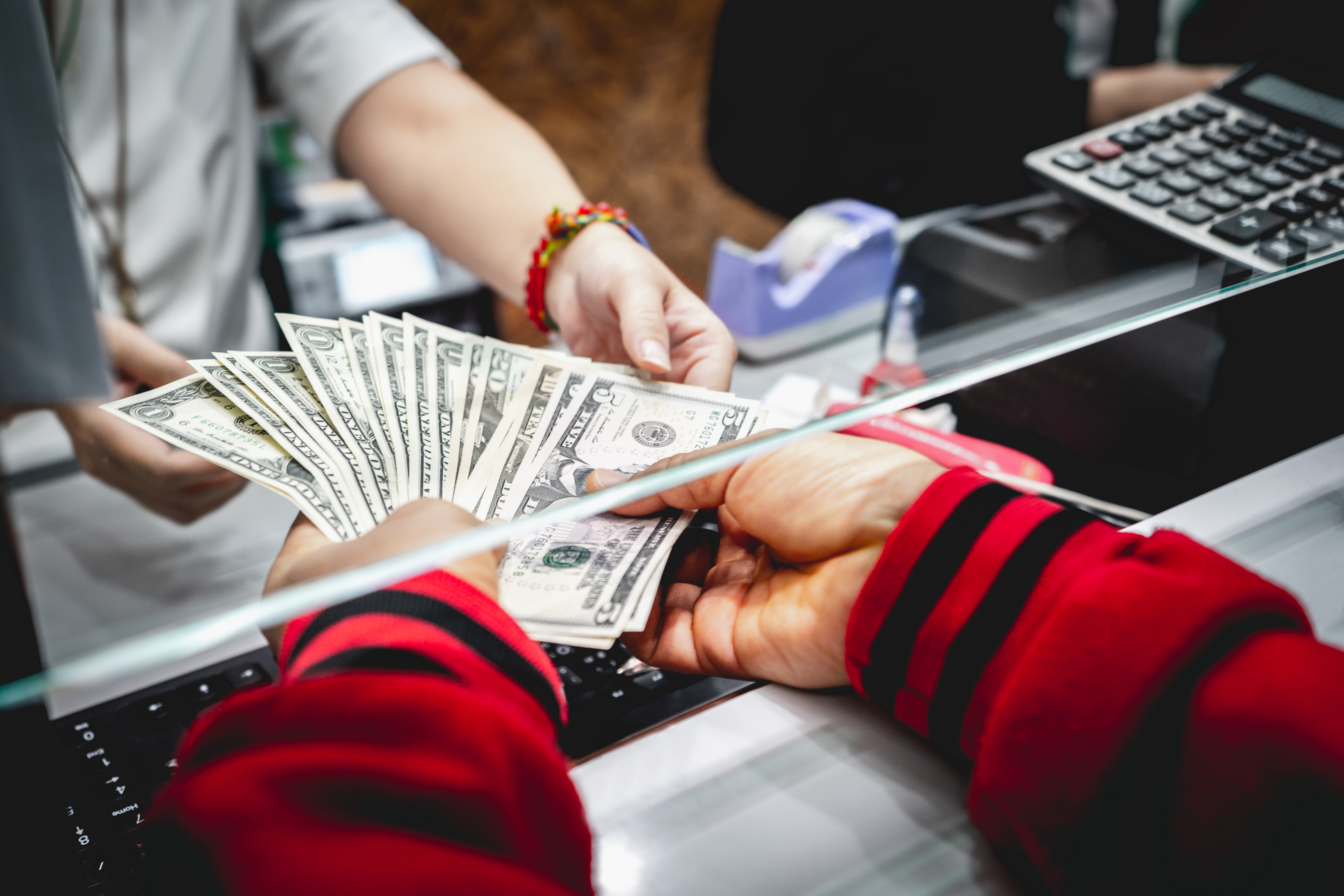 Cash is exchanged in a file photo. (Credit: Getty Images)