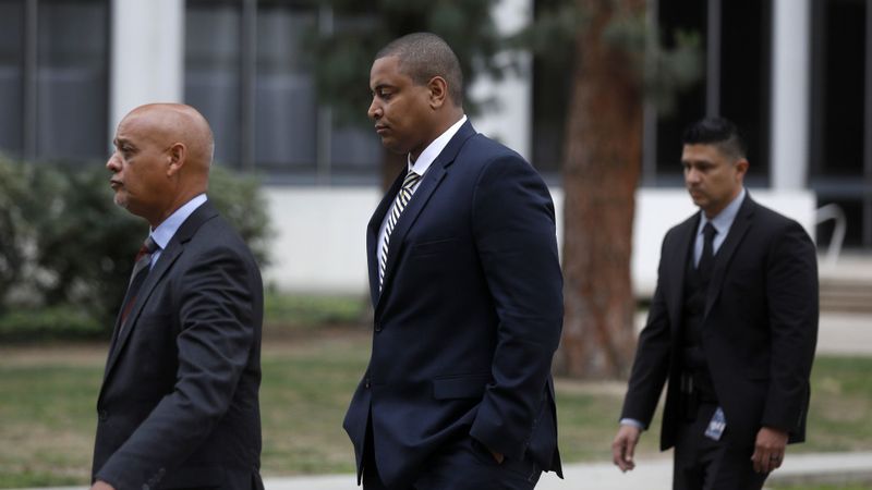 Jonathan Martin, center, walks after a court hearing sometime in 2018 after being charged with making criminal threats involving his high school, Harvard-Westlake. (Credit: Gary Coronado / Los Angeles Times)