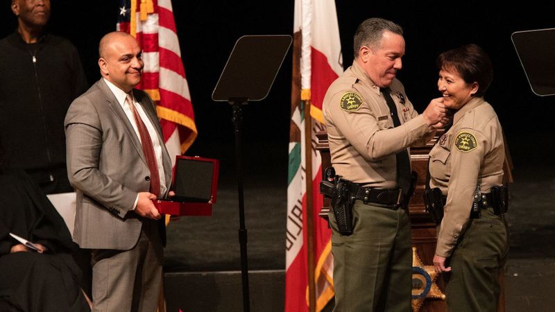 Deputy Caren Carl Mandoyan looks on as L.A. County Sheriff Alex Villanueva places a pin on the collar of Asst. Sheriff Maria Gutierrez at Villanueva's swearing-in ceremony in December 2018. (Credit: Mel Melcon / Los Angeles Times)