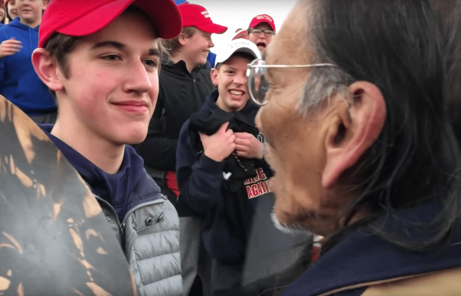 A screenshot from a video posted to YouTube on Jan. 18, 2019 by user KC NOLAND shows a boy wearing a MAGA hat in front of a Native American man.