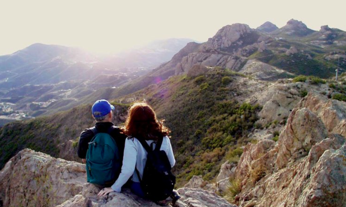 Hikers rest on a rock on a trail in the Santa Monica Mountains. (Credit: Santa Monica Mountains/ National Park Service)