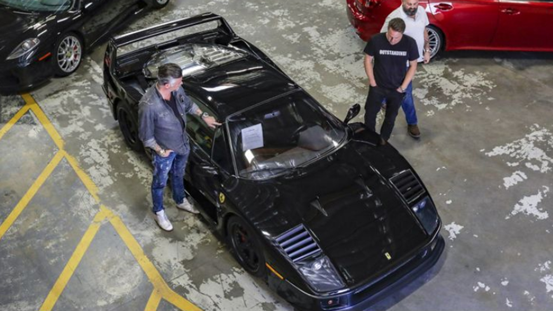 The owner of Gas Monkey Garage and TV personality Richard Rawlings, left, Dennis Collins and his cohost Russel Holmes check out a 1991 Ferrari F40 at Apple Auctioneering Co., which manages government assets and auctions them off online. The vehicle ended up selling for $760,000. (Irfan Khan / Los Angeles Times)