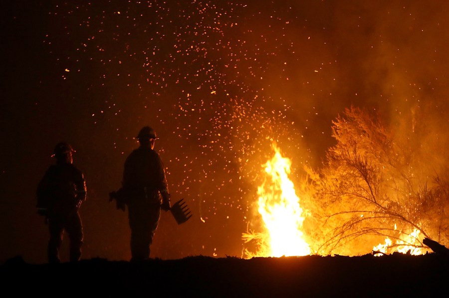 Cal Fire firefighters monitor a back fire as they battle the Medocino Complex Fire on Aug. 7, 2018, near Lodoga. (Credit: Justin Sullivan/Getty Images)