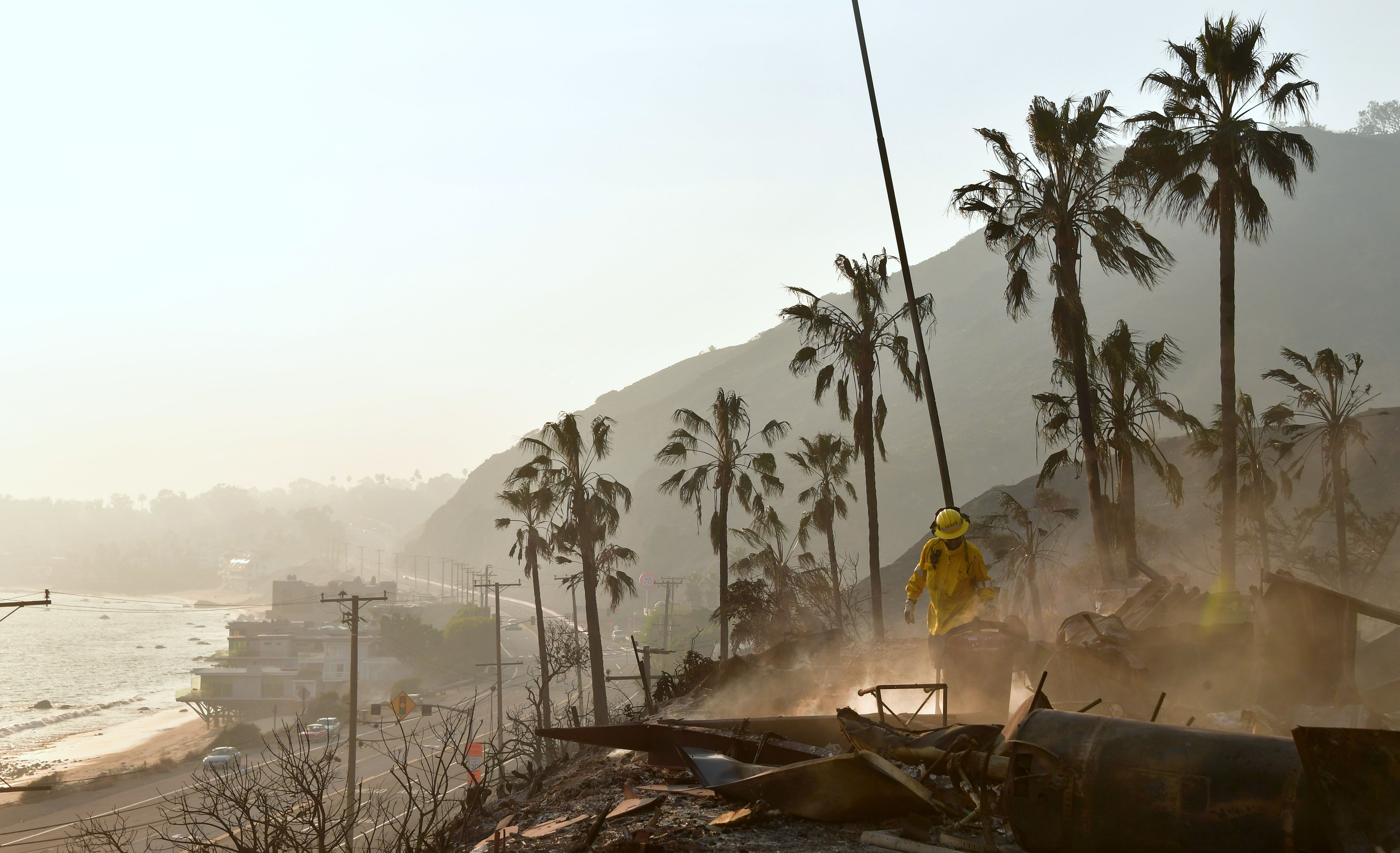 A firefighter puts out burning embers at the Malibu RV Park along the Pacific Coast Highway in Malibu on Nov. 10, 2018. (Credit: Frederic J. Brown/AFP/Getty Images)