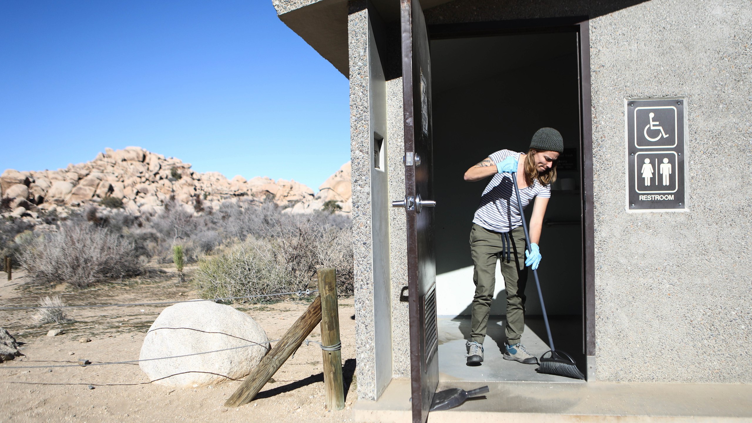 Volunteer Alexandra Degen cleans a restroom at Joshua Tree National Park on January 4, 2019 in Joshua Tree National Park, California. (Credit: Mario Tama/Getty Images)