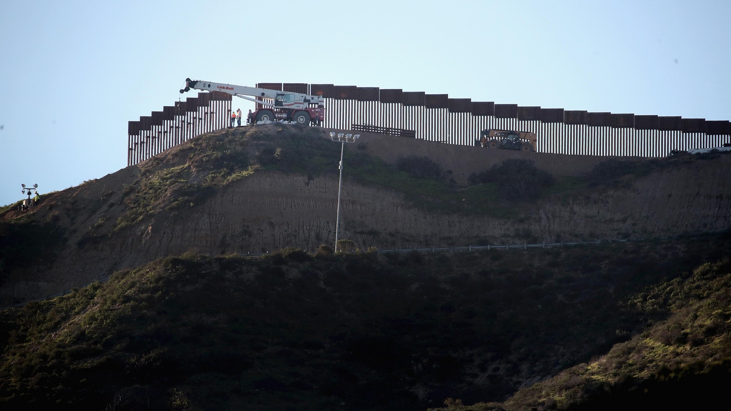 Workers construct a barrier between the United States and Mexico in San Diego County on Jan. 23, 2019. (Credit: Scott Olson / Getty Images)