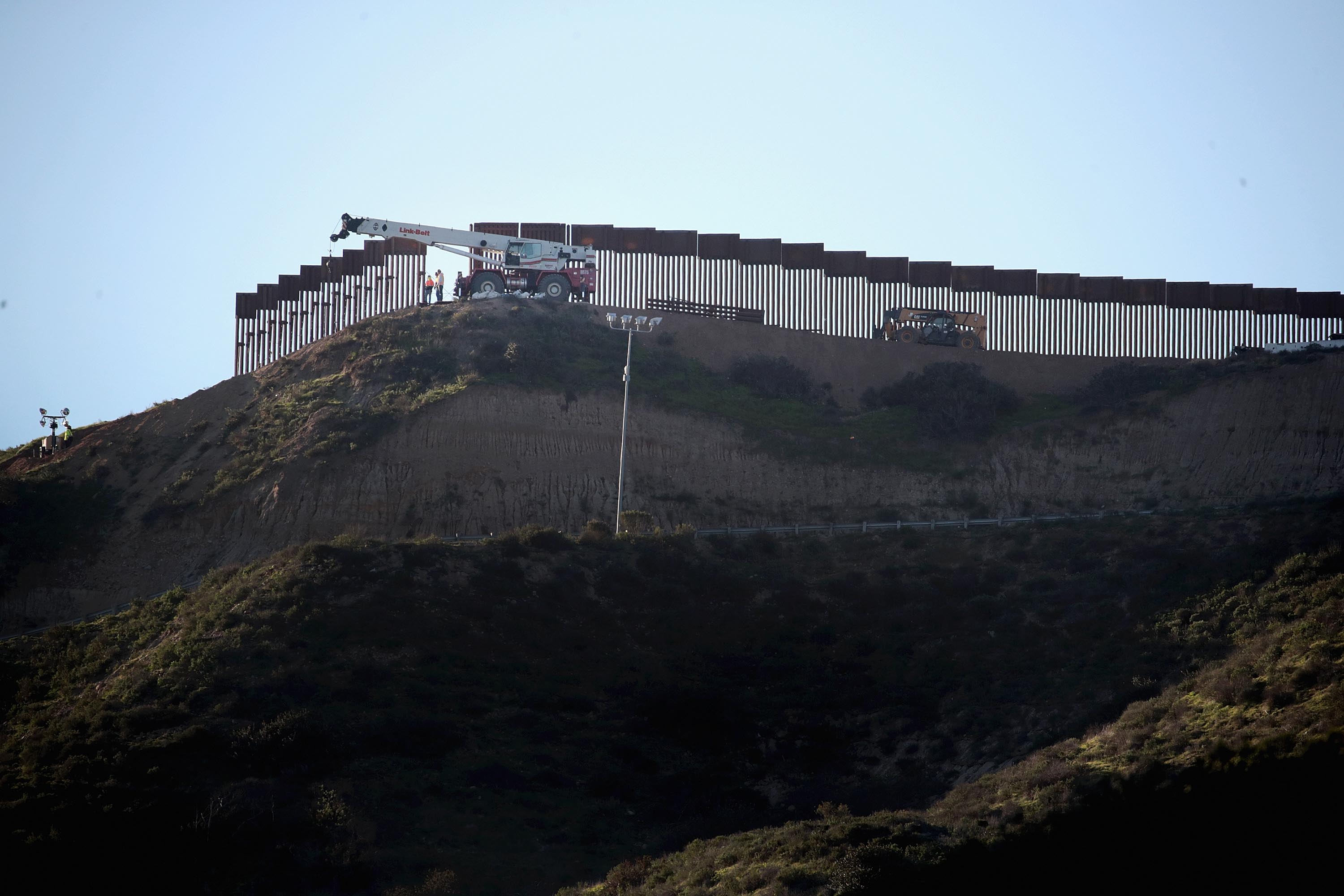 Workers construct a barrier between the United States and Mexico in San Diego County on Jan. 23, 2019. (Credit: Scott Olson / Getty Images)