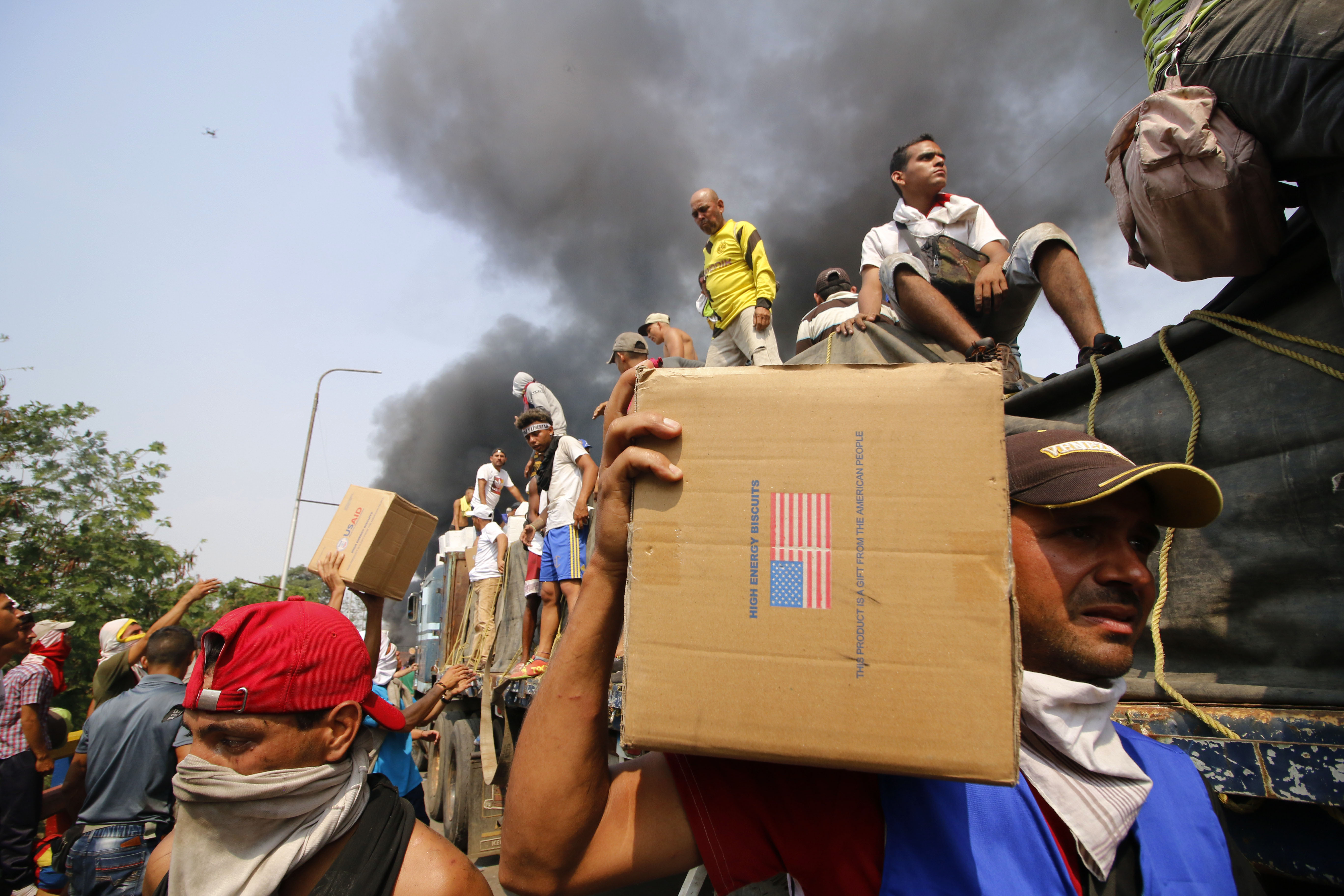 People try to salvage humaitarian aid after the truck carrying it was set ablaze on the Francisco de Paula Santander International Brige between Cucuta in Colombia and Ureña in Venezuela, on Feb. 23, 2019. (Credit: SCHNEYDER MENDOZA/AFP/Getty Images)