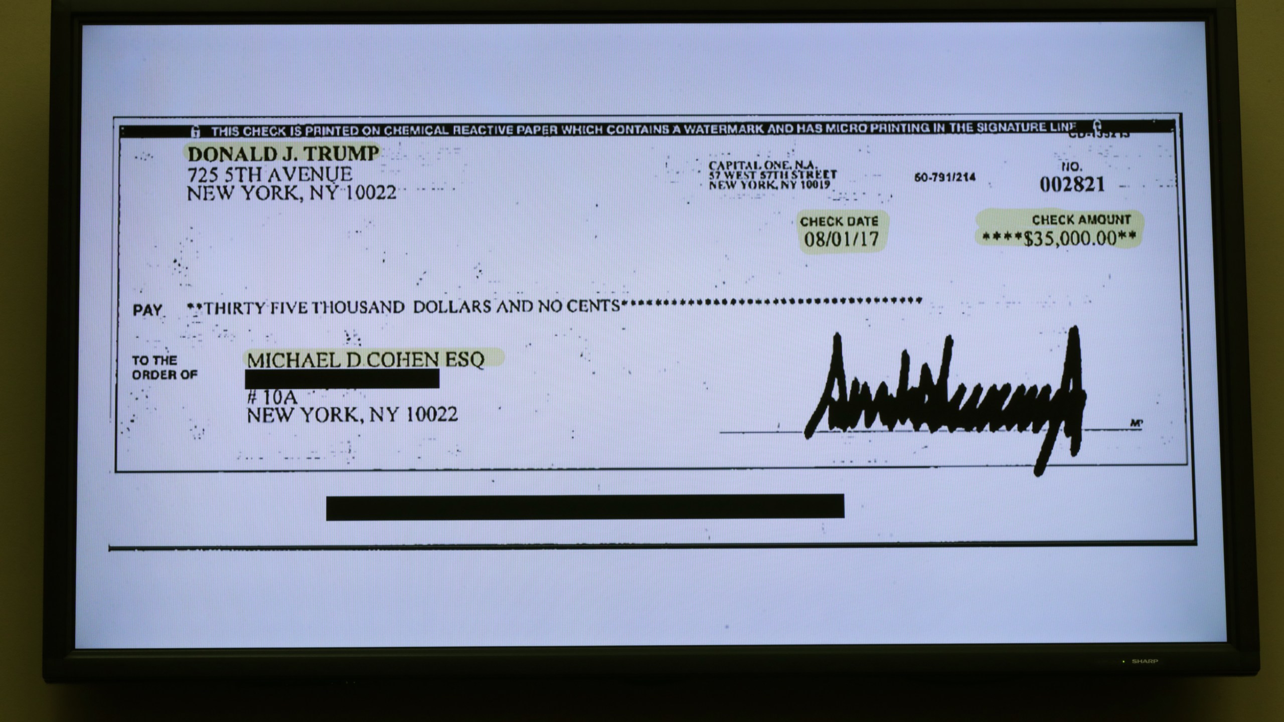 A copy of a check paid to Michael Cohen by President Trump is displayed as Cohen, former attorney and fixer for Trump testifies before the House Oversight Committee on Capitol Hill February 27, 2019 in Washington, DC. (Credit: Chip Somodevilla/Getty Images)