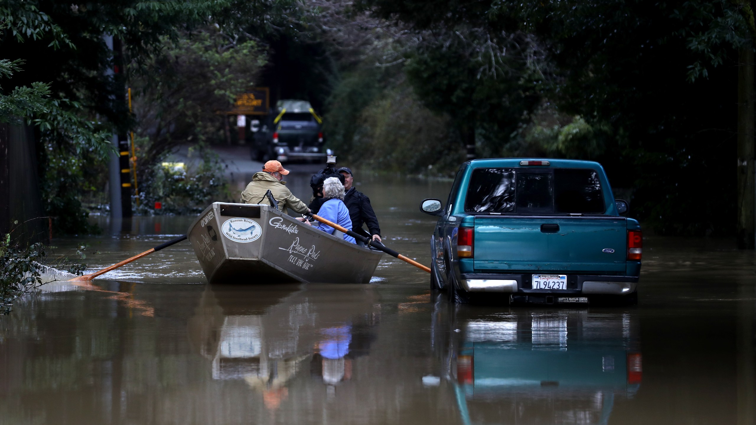 Residents use a boat to navigate floodwaters around the Russian River in Guerneville, California, on Feb. 15, 2019. (Credit: Justin Sullivan / Getty Images)