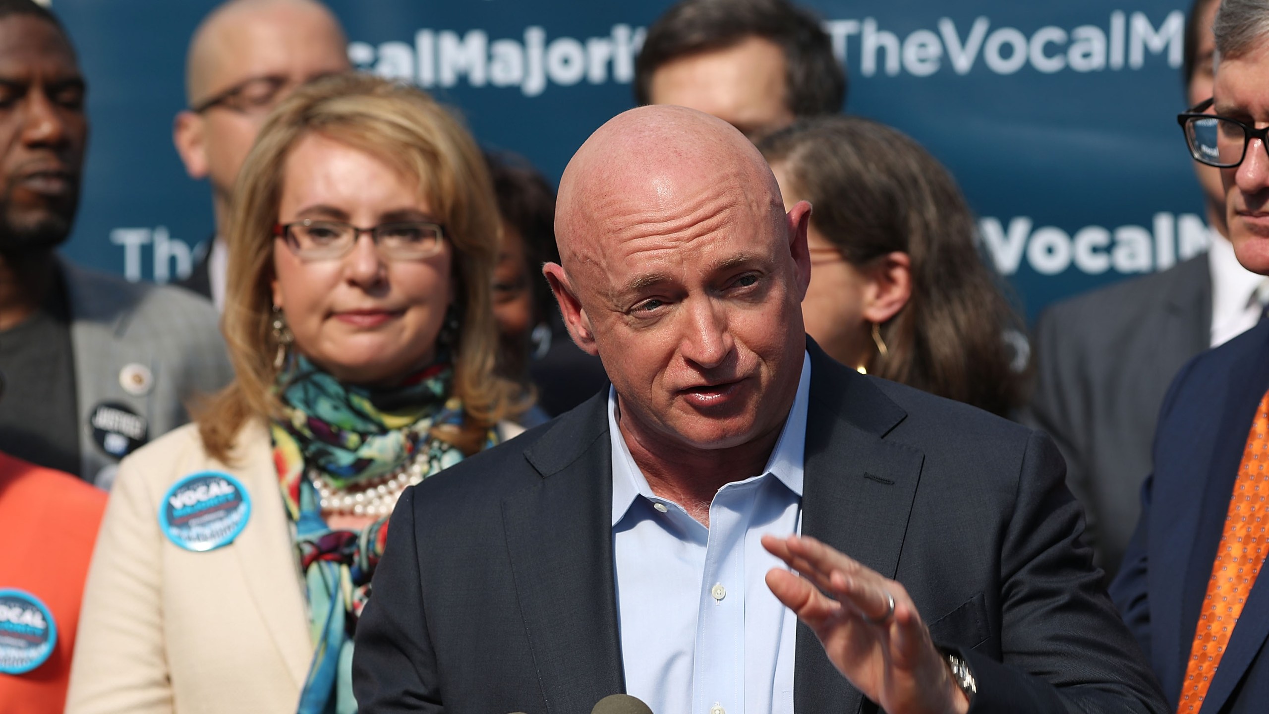 Gun violence victim and former U.S. Congresswoman Gabby Giffords watches her husband, NASA astronaut Mark Kelly, speak as they visits City Hall on her 2016 Vocal Majority Tour on October 17, 2016 in New York City. (Credit: Spencer Platt/Getty Images)