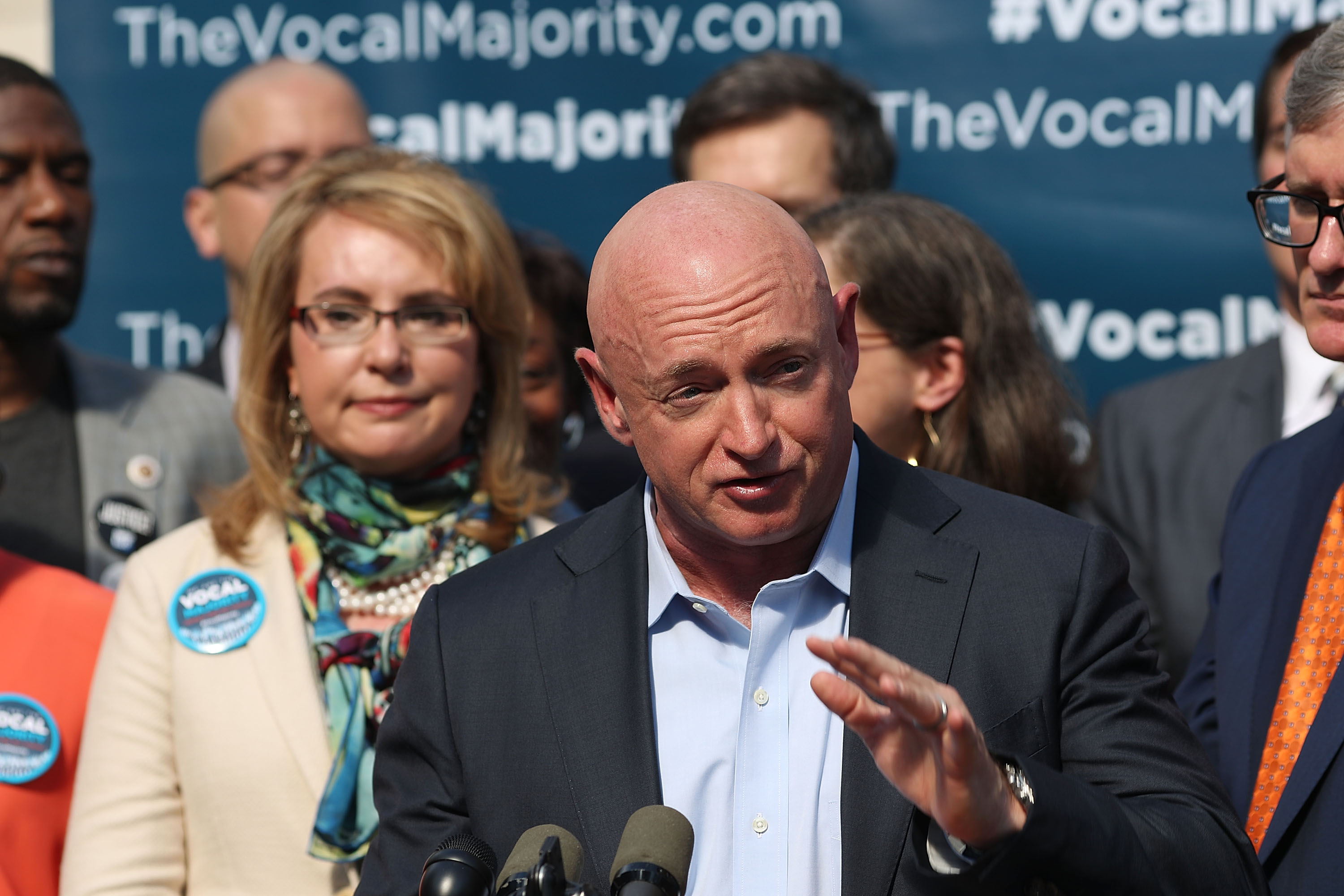 Gun violence victim and former U.S. Congresswoman Gabby Giffords watches her husband, NASA astronaut Mark Kelly, speak as they visits City Hall on her 2016 Vocal Majority Tour on October 17, 2016 in New York City. (Credit: Spencer Platt/Getty Images)