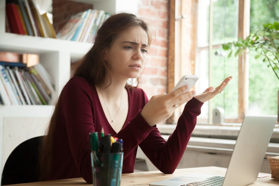 A frustrated woman stares at her phone in this file photo. (Getty Images)