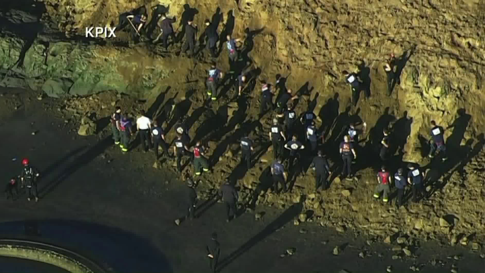 Rescue workers search for the body of a woman believed to be buried by a landslide at Fort Funston beach in San Francisco on Feb. 22, 2019. (Credit: KPIX via CNN)