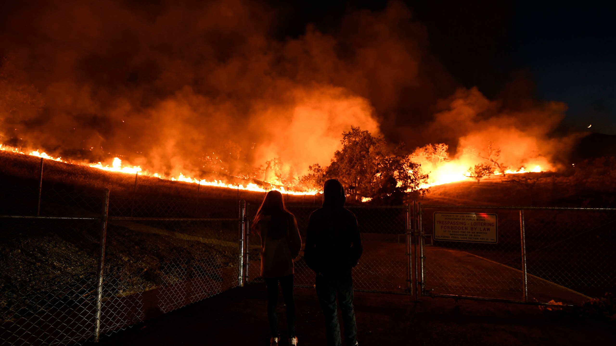 Residents take a look at the Woolsey Fire burning brush and trees on Nov. 9, 2018, in Agoura Hills. (Credit: Kevork Djansezian/Getty Images)