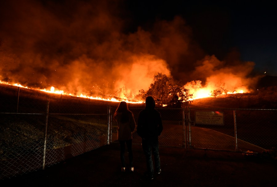 Residents take a look at the Woolsey Fire burning brush and trees on Nov. 9, 2018, in Agoura Hills. (Credit: Kevork Djansezian/Getty Images)