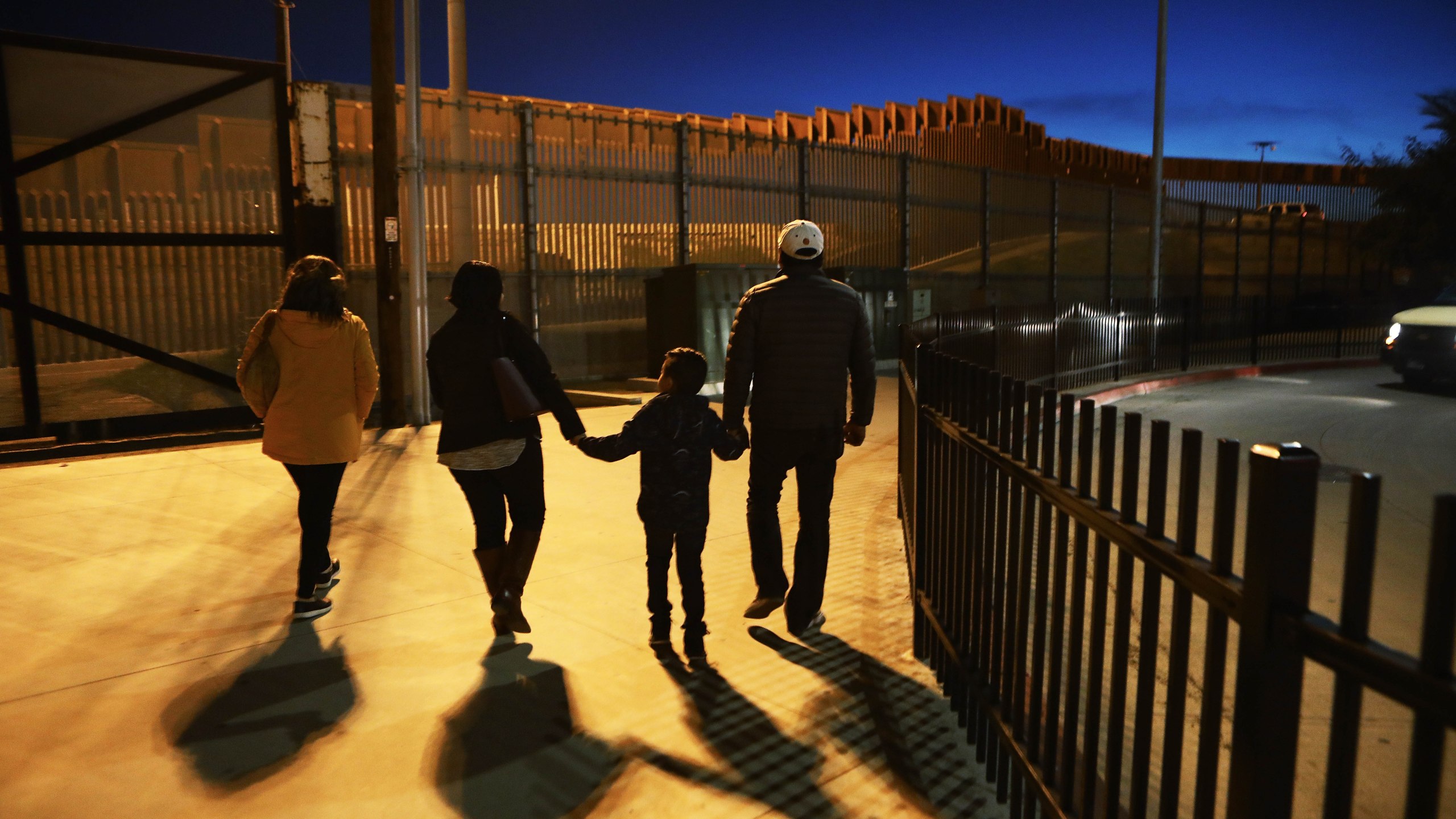 People walk on a sidewalk on the U.S. side of the U.S.-Mexico border barrier in San Diego on Jan. 25, 2019. (Credit: Mario Tama / Getty Images)