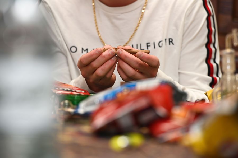 A man on a cannabis tour of Los Angeles rolls a joint as the group makes a stop to smoke marijuana on Jan. 24, 2019. (Credit: Robyn Beck / AFP / Getty Images)