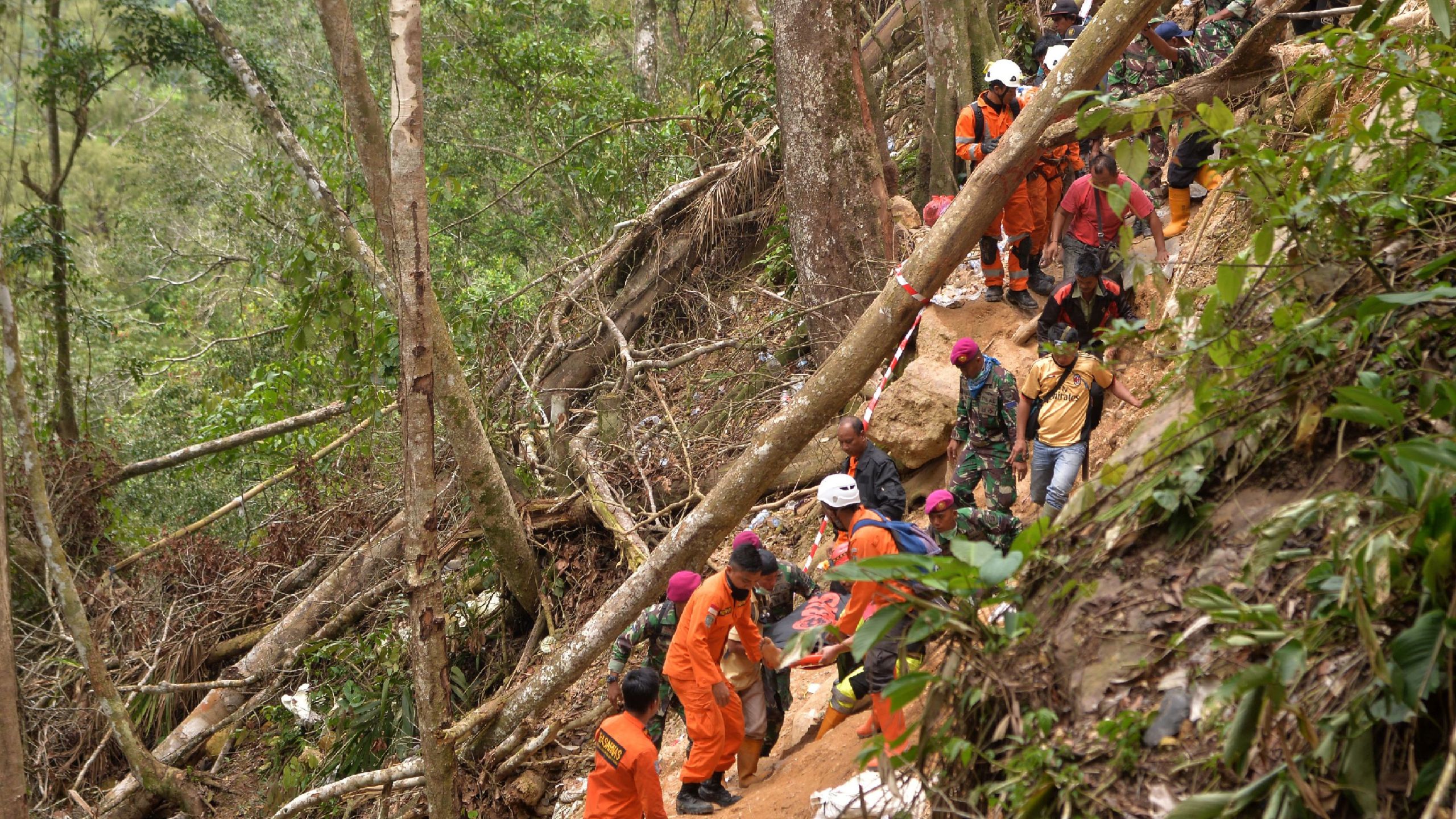 Members of an Indonesian search and rescue team carry a survivor after a mine collapsed in Bolaang Mongondow, North Sulawesi on February 28, 2019. (Credit: UNGKE PEPOTOH/AFP/Getty Images)